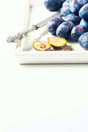 Ripe plums scattered on wooden background. Selective focus. Copy space backgroundの写真素材