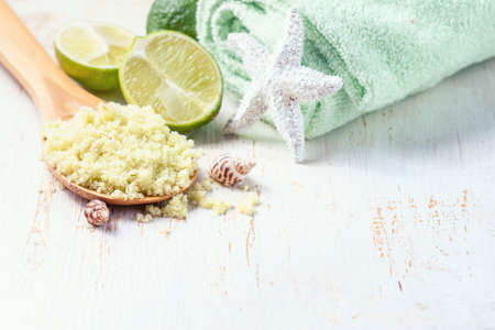 Spa set on wooden background. Green sea salt, towels and lime on aged wooden background. Selective focus.の写真素材