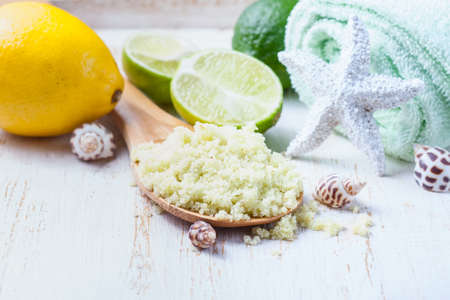 Spa set on wooden background. Green sea salt, towels and lime on aged wooden background. Selective focus.の写真素材