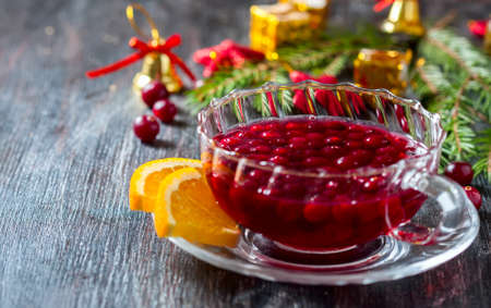 Christmas hot cranberry tea, cookies and orange slices, on dark background. Christmas decoration. Selective focusの写真素材