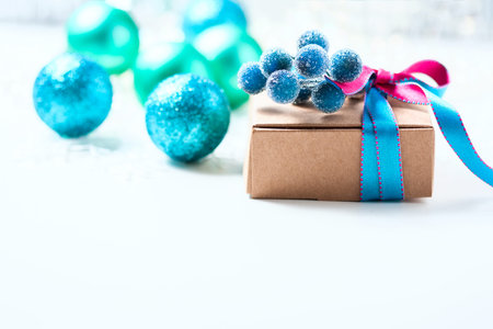 Christmas gift box with ribbon and christmas decoration on a white background, soft focus