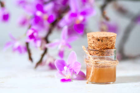 spa setting with cosmetic cream, gel and purple orchid on white wooden table background. Selective focusの写真素材