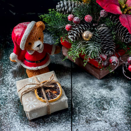 Santa Teddy Bear, Gift box wrapped linen cloth and decorated with linen cord, christmas decoration on brown vintage wooden boards background. Selective focusの写真素材