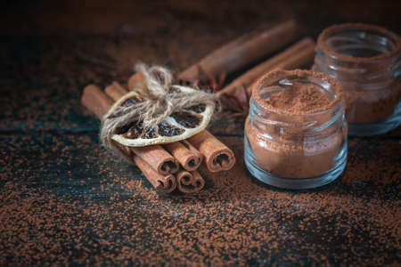 Cinnamon sticks and cinnamon powder close up on wooden background, rustic style, selective focusの写真素材
