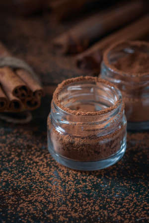 Cinnamon sticks and cinnamon powder close up on wooden background, rustic style, selective focusの写真素材