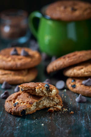 Oatmeal cookies with raisins, chocolate folded in a pile on the old table, wood background, selective focusの写真素材