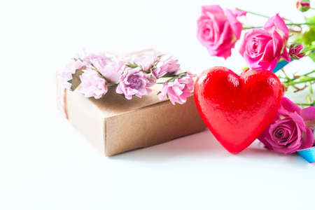 Kraft box and pink roses on white table, concept of Valentines Day, holiday. Selective focus. Red heart.の写真素材