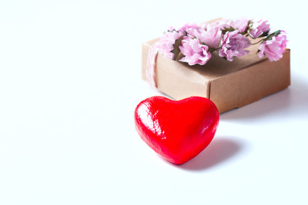 Kraft box and pink roses on white table, concept of Valentines Day, holiday. Selective focus. Red...