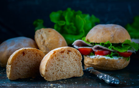 Homemade sandwich with ham and vegetables on wooden background. Selective focus