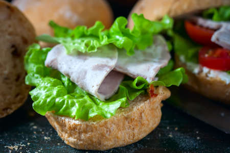 Homemade sandwich with ham and vegetables on wooden background. Selective focusの写真素材