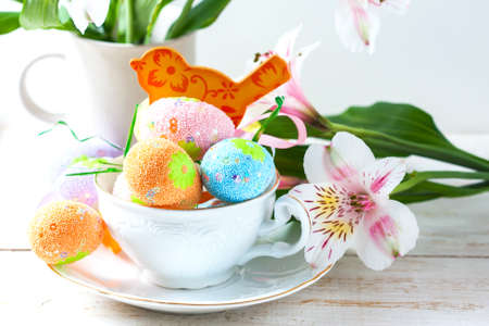 Easter eggs with spring flowers on table. Selective focusの写真素材