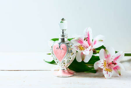Luxurious perfume bottle with flowers on white background. Feminine beauty concept. Selective focusの写真素材
