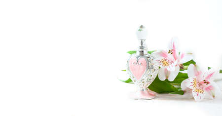 Luxurious perfume bottle with flowers on white background. Feminine beauty concept. Selective focusの写真素材