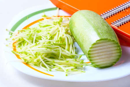 Grater and grated zucchini. Selective focusの写真素材