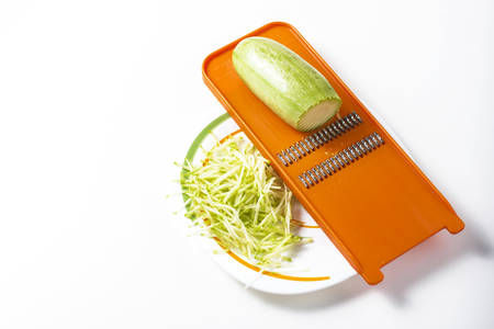Grater and grated zucchini. Selective focusの写真素材