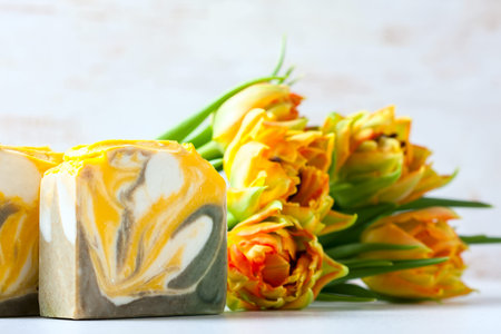 Composition with beautiful tulips and soap on white background. Selective focus