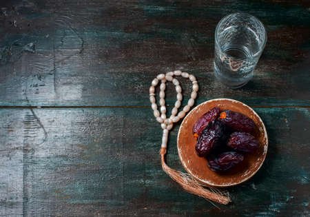 Dates fruit and rosary still life, on a dark wooden background. Selective focusの写真素材