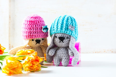 Handmade crochet rabbit toys on green background. Amigurumi doll. Selective focusの写真素材