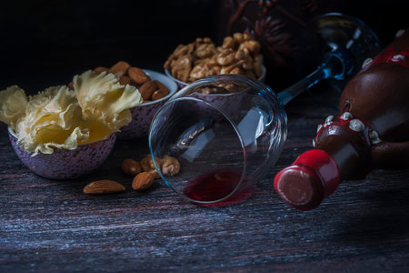 Ceramic jug for wine , cheese, nuts on a wooden board, background. Selective focus