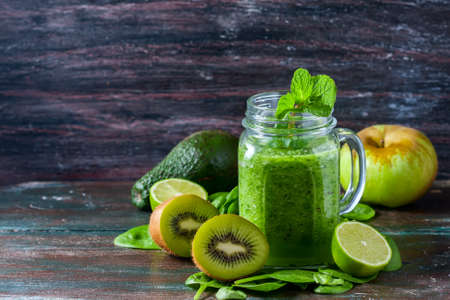 Healthy green smoothie on a dark wooden background. Vegetarian food concept, detox, fitness. Selective focusの写真素材