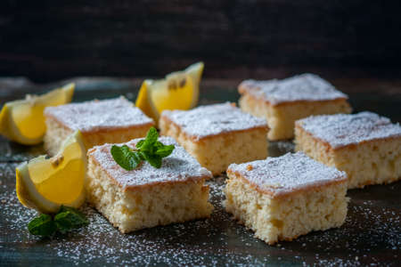 Fresh homemade sweet cake for breakfast with slices of lemon and mint on wooden board. Selective Focusの写真素材