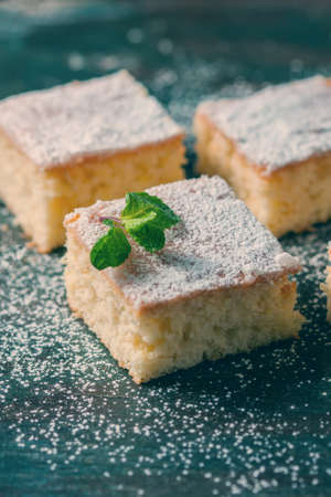 Fresh homemade sweet cake for breakfast with slices of lemon and mint on wooden board. Selective Focusの写真素材