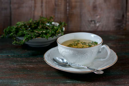 Cup of herbal tea with thyme n a wooden table. Selective focusの写真素材
