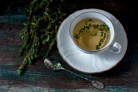 Cup of herbal tea with thyme n a wooden table. Selective focusの写真素材