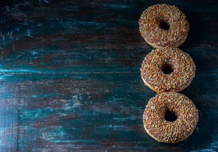 Donuts with chocolate and nuts on a dark wooden background. Selective focusの写真素材