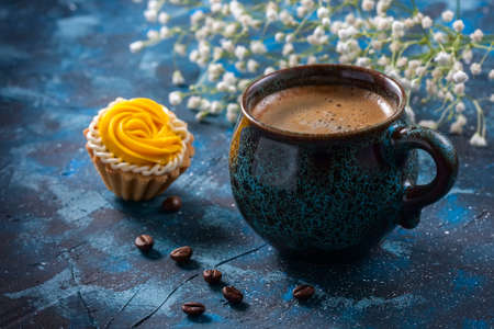 ?offee in blue cup, and delicious cakes on dark blue background, selective focusの写真素材