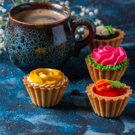 ?offee in blue cup, and delicious cakes on dark blue background, selective focusの写真素材