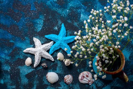 Beautiful sea composition. Seashells, starfish, copy space on a dark blue background. Travel and adventure conceptの写真素材