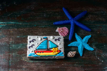Homemade homemade gingerbread cookie in the shape of a boat on the dark dark wooden background. Selective focus.の写真素材