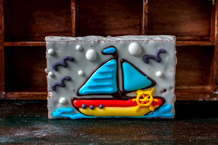 Homemade homemade gingerbread cookie in the shape of a boat on the dark dark wooden background. Selective focus.の写真素材