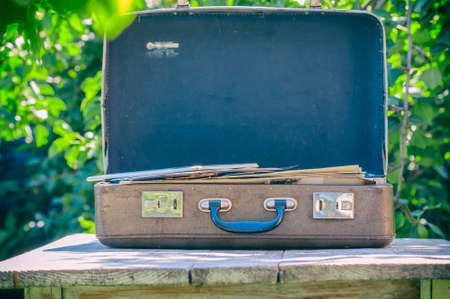 Vintage brown leather suitcase on a wooden table. The concept of travel. Natural light, selective focusの写真素材