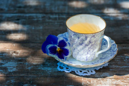 Porcelain cup of tea on a wooden table in the garden. Summer party. Selective focusの写真素材