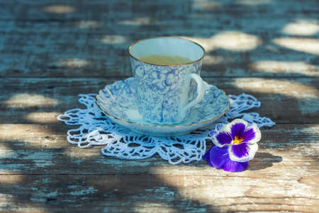 Porcelain cup of tea on a wooden table in the garden. Summer party. Selective focusの写真素材