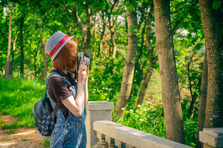 Girl in jeans clothes shooting with instant camera, snapshots outdoor.の写真素材