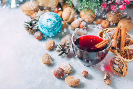 Christmas composition. Glass of red mulled wine on table with cinnamon sticks, Christmas decorations. Selective focusの写真素材