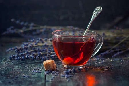 A cup of hot black tea with sugar and lavender on a dark wooden background. Breakfast concept. Selective focusの写真素材