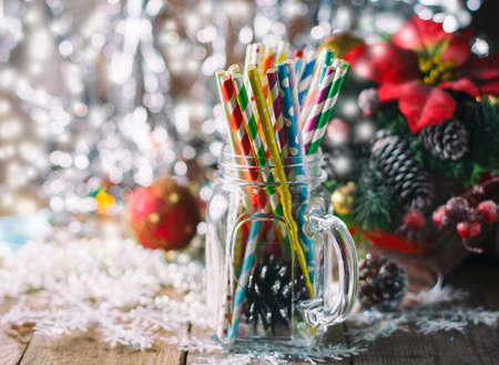 Multicolored spiral straw cocktails in a glass jar Mason on a festive New Year's background. Sweet table. A table with a drink. Selective focusの写真素材
