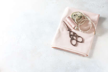 Everything for sewing. Beige fabric, sewing accessories and scissors. Seletive focusの写真素材