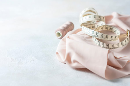 Everything for sewing. Beige fabric, sewing accessories and scissors. Seletive focus