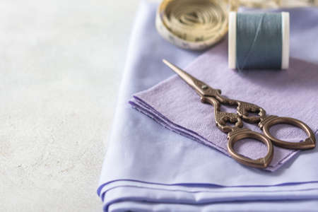 Everything for sewing. Beige fabric, sewing accessories and scissors. Seletive focusの写真素材