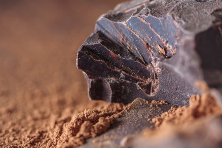 dark chocolate, cocoa solids and cocoa powder over wooden background, selective focus