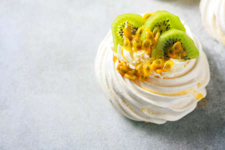 Homemade cake Pavlova with whipped cream, fresh kiwi and passion fruit.の写真素材