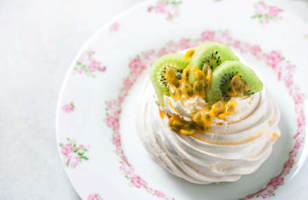 Homemade cake Pavlova with whipped cream, fresh kiwi and passion fruit. Selective focusの写真素材
