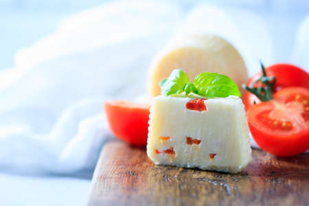 Homemade cheese with tomatoes on a light background. Copy space background. Selective focusの写真素材