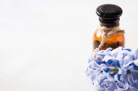Bottle with essential oil and with lilac flowers on a white background. Macro. Selective focusの写真素材