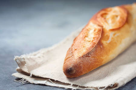 Fresh homemade crispy baguette on linen cloth. Copy space. Selective focusの写真素材